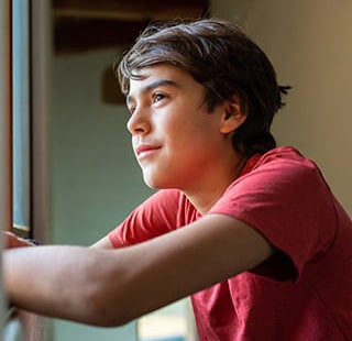 Teen looking out window